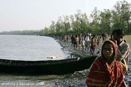People waiting for aid by a riverbank in Bangladesh, 2007.