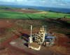 Biomass gasifier uses residue from sugarcane mill, with sugarcane fields and ocean in the background
